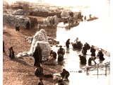 Wool-washing by the banks of the river Tigris. Fleeces of skin-wool obtained for the sheep after killing, are piled high in bales. Shorn wool rather than skin-wool was approved by the Hebrews. An early photograph.